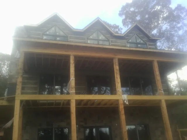 Dormers and porch framing on a large log home under construction — Roof Coating work by our crew in Ivins