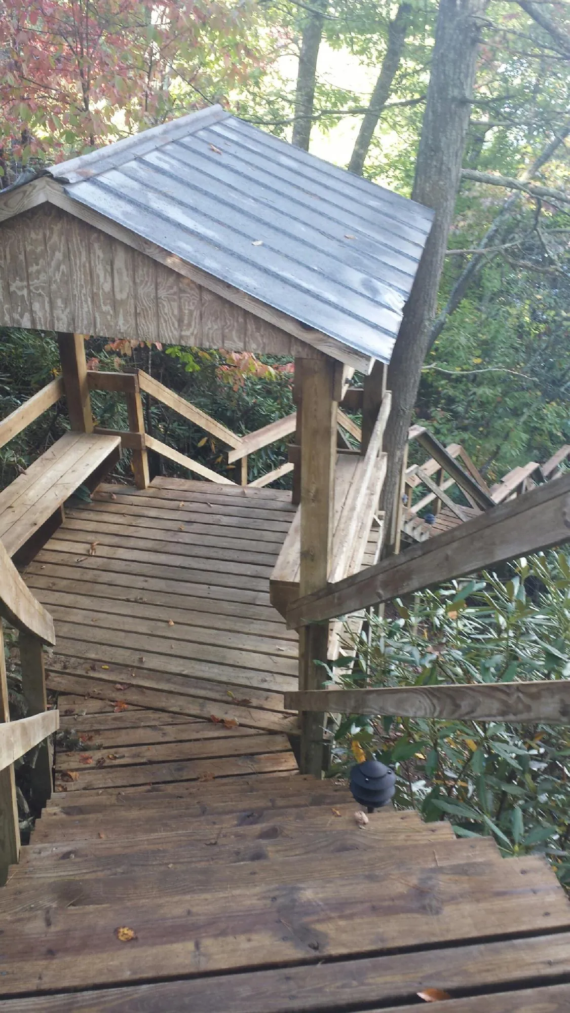 Metal roofed shelter over wooden steps on a wooded walkway — Skylight Repair & Installation work by our crew in Ivins